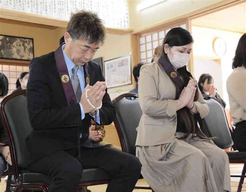 清水心ちゃんの法要で手を合わせる父の誠一郎さん（左）と母の真夕さん＝3日、熊本市中央区