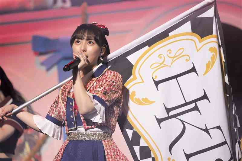 「HKT48」の団旗を掲げ凜々しい表情で「意志」を歌う田中美久（ⓒMercury）