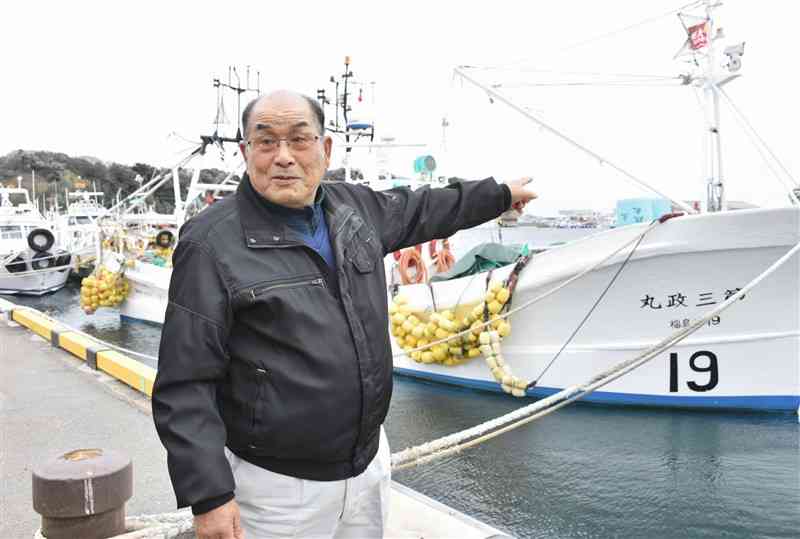 所有する「第三政丸」の前に立つ志賀金三郎さん。処理水の海洋放出について「漁師は了解していない」と憤る＝2月27日、福島県いわき市