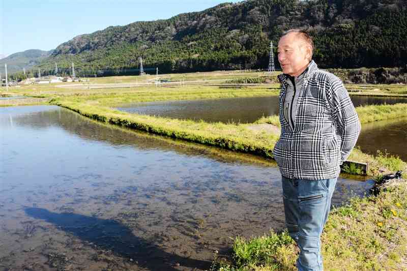 地下水を蓄えるために水を張った田んぼを見て回る瀬川友次さん＝10日、大津町