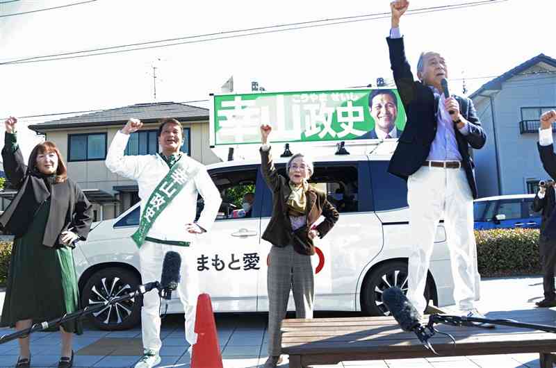 熊本県知事選に立候補した幸山政史氏の街頭演説に駆け付けて拳を突き上げる潮谷義子氏（中央右）＝16日、八代市