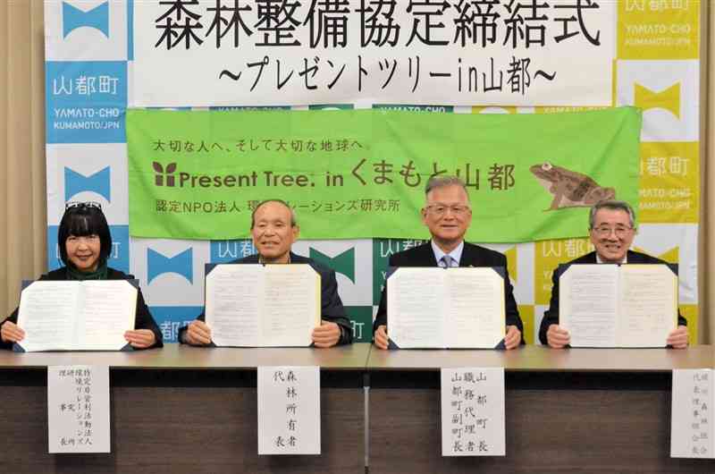 耕作放棄された茶畑に植樹する協定を結んだNPO法人環境リレーションズ研究所の鈴木敦子理事長（左）ら＝22日、山都町