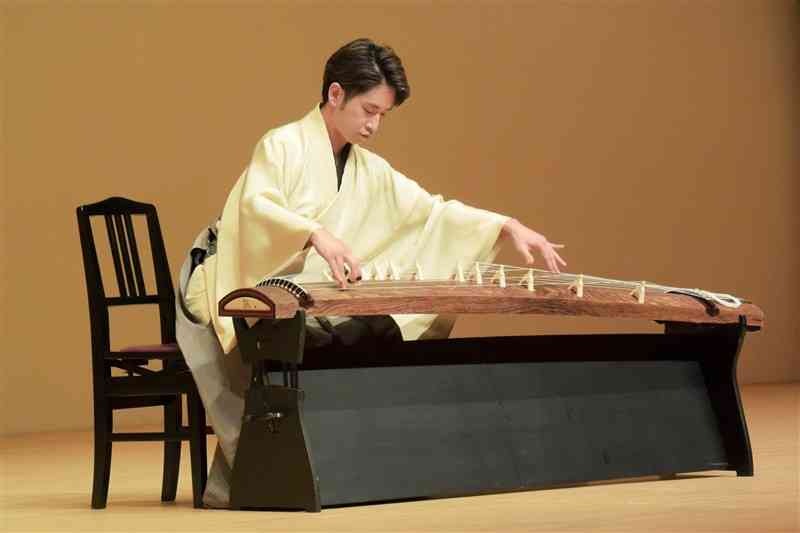 流麗な爪さばきで多彩な音色を奏でる中島裕康さん＝22日、熊本市西区
