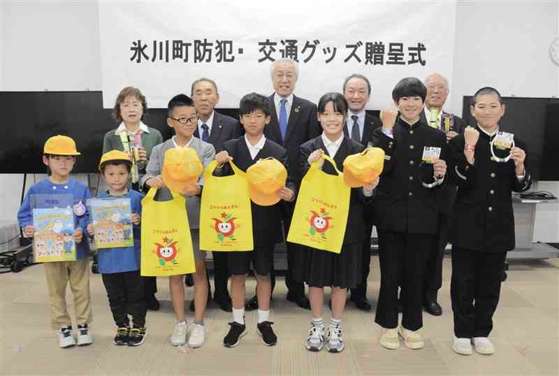 防犯・交通安全グッズをもらった未就学児や児童生徒、高齢者ら＝26日、氷川町