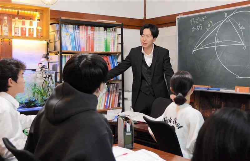 実家を改装した「励心塾」で中学生に数学を教える橋本大介さん＝1月18日、八代市