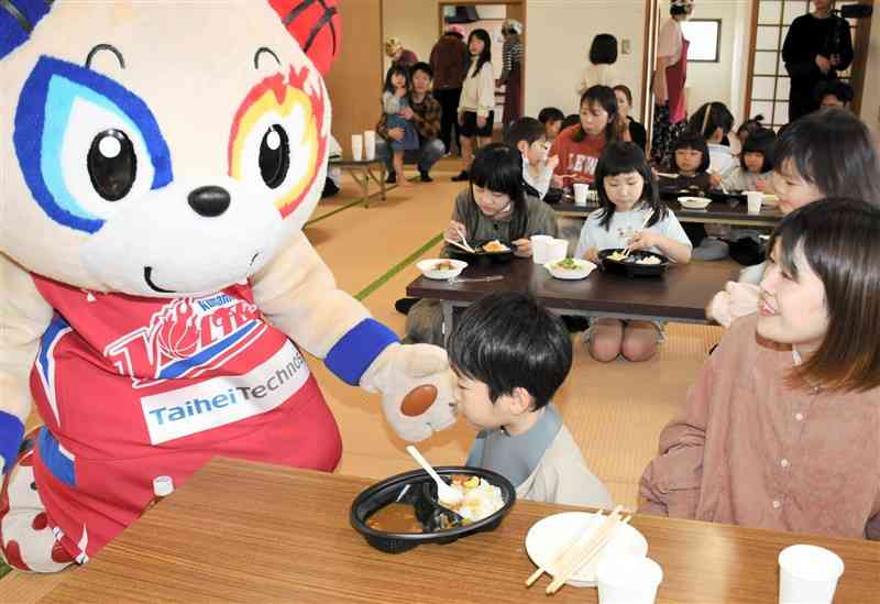 熊本ヴォルターズのマスコット「ぼるたん」と食事を楽しむ親子連れら＝31日、嘉島町