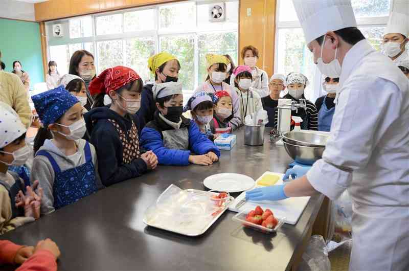 ホテル日航熊本のパティシエ髙本健太さん（右）から、デザートの作り方を教わる子どもたち＝3月20日、山都町
