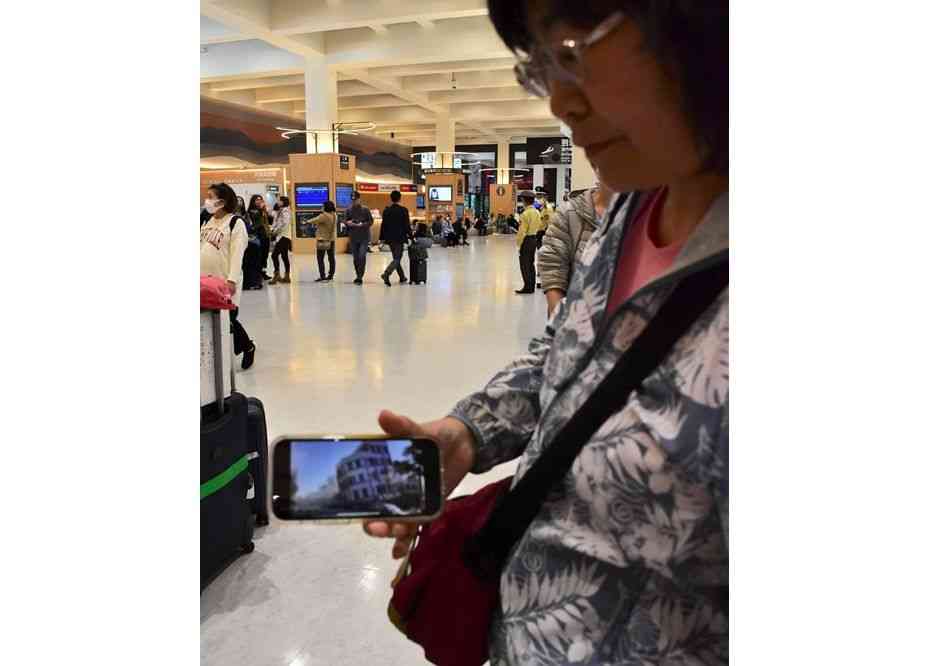 熊本空港に到着後、台湾で発生した地震の被害をスマートフォンで確認する台湾人女性＝3日、益城町