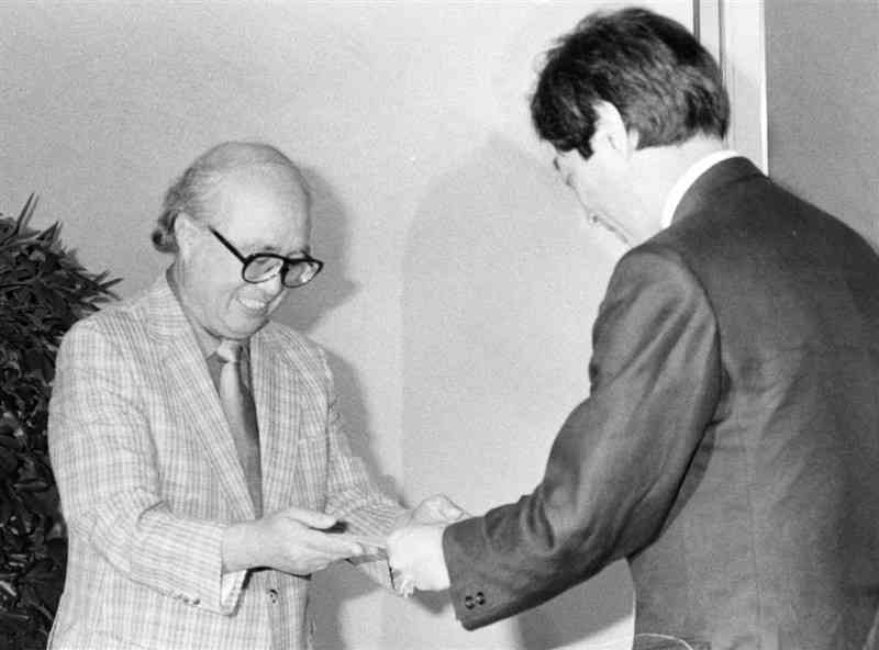 細川護熙知事（右）から熊本県立劇場館長の辞令を受け取る鈴木健二さん＝1988年7月、熊本市