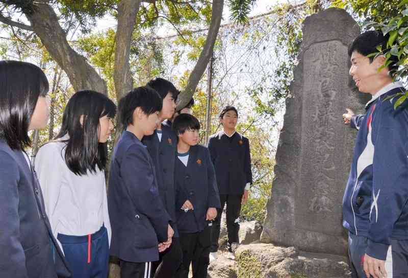 「桜島爆発記念碑」について説明を聞く児童たち＝3月、鹿児島市の東桜島小学校（南日本新聞社）