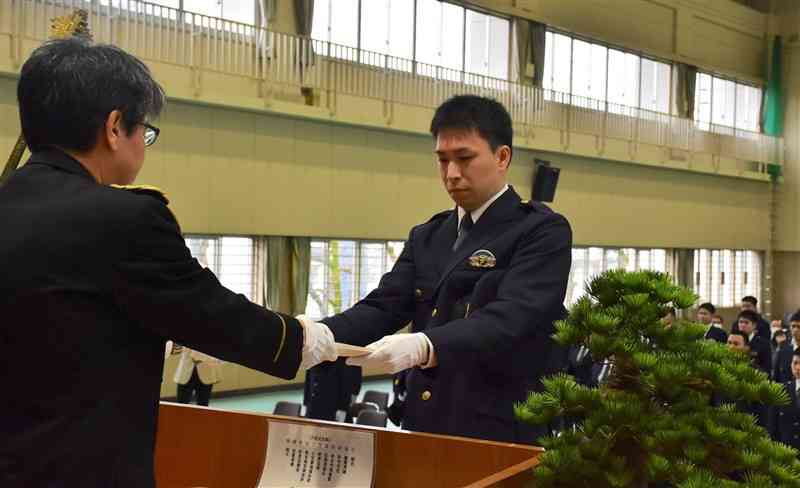 宮内彰久県警本部長（左）から辞令を受ける中村圭佑巡査＝5日、熊本市