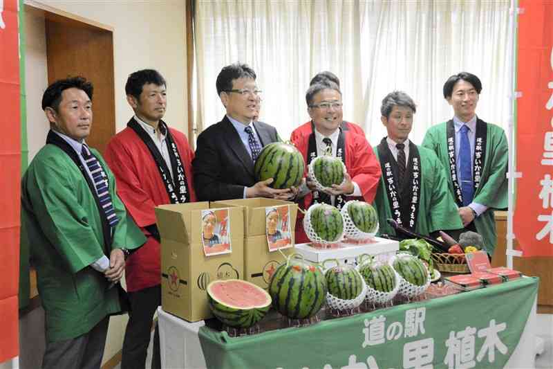 特産のスイカを熊本市の大西一史市長（左から3人目）に贈った道の駅「すいかの里植木」出荷者協議会のメンバーら＝5日、市役所
