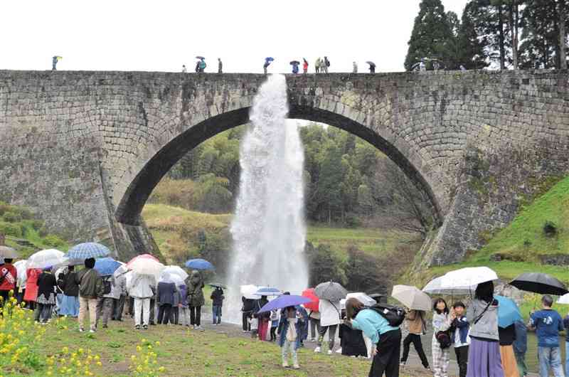 小雨の中、２０２４年度の放水が始まった国宝・通潤橋＝6日、山都町