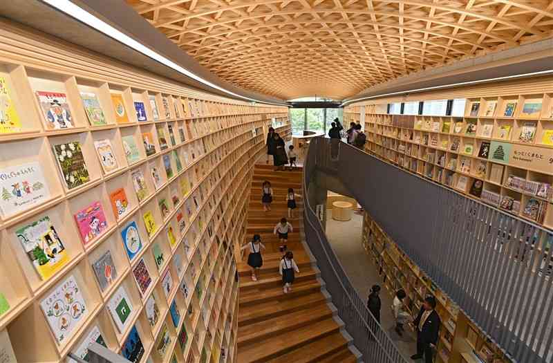 完成した「こども本の森　熊本」。内覧会に招かれた園児たちが楽しそうに絵本を探していた＝7日、熊本市中央区（小野宏明）