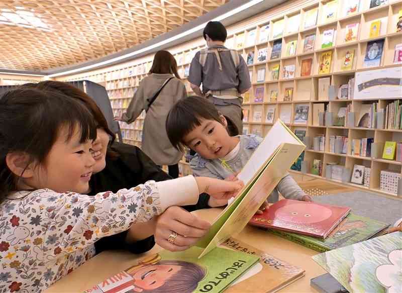 開館した「こども本の森　熊本」で絵本を読む子どもたち＝8日午後、熊本市中央区（谷川剛）