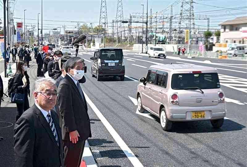 4車線化の工事着手から6年後、一部供用が始まった県道熊本高森線。蒲島郁夫知事も通行する車を見送った＝2023年3月、益城町