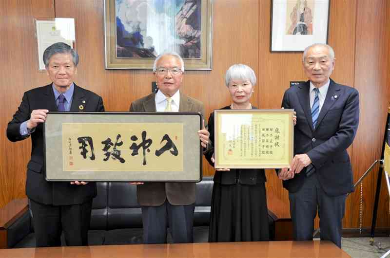 熊本大の小川久雄学長（左端）から感謝状を受け取った田添英明さん（左から2人目）と田尻節子さん（同3人目）＝18日、熊本市中央区