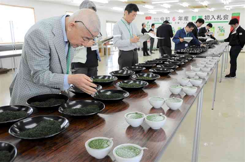 熊本県産一番茶の初入札会で、茶葉の香りを確かめる商社の担当者ら＝19日、益城町