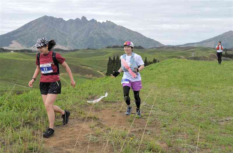 根子岳を背に草原を快走する参加者たち＝20日、阿蘇市