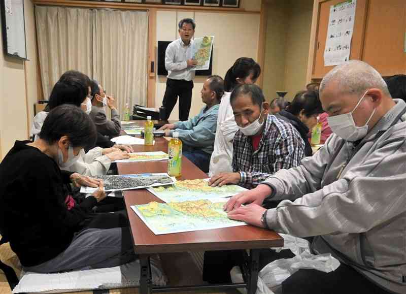 模型地図を実際に触れて、人吉球磨の地形を確認する参加者ら＝21日、人吉市