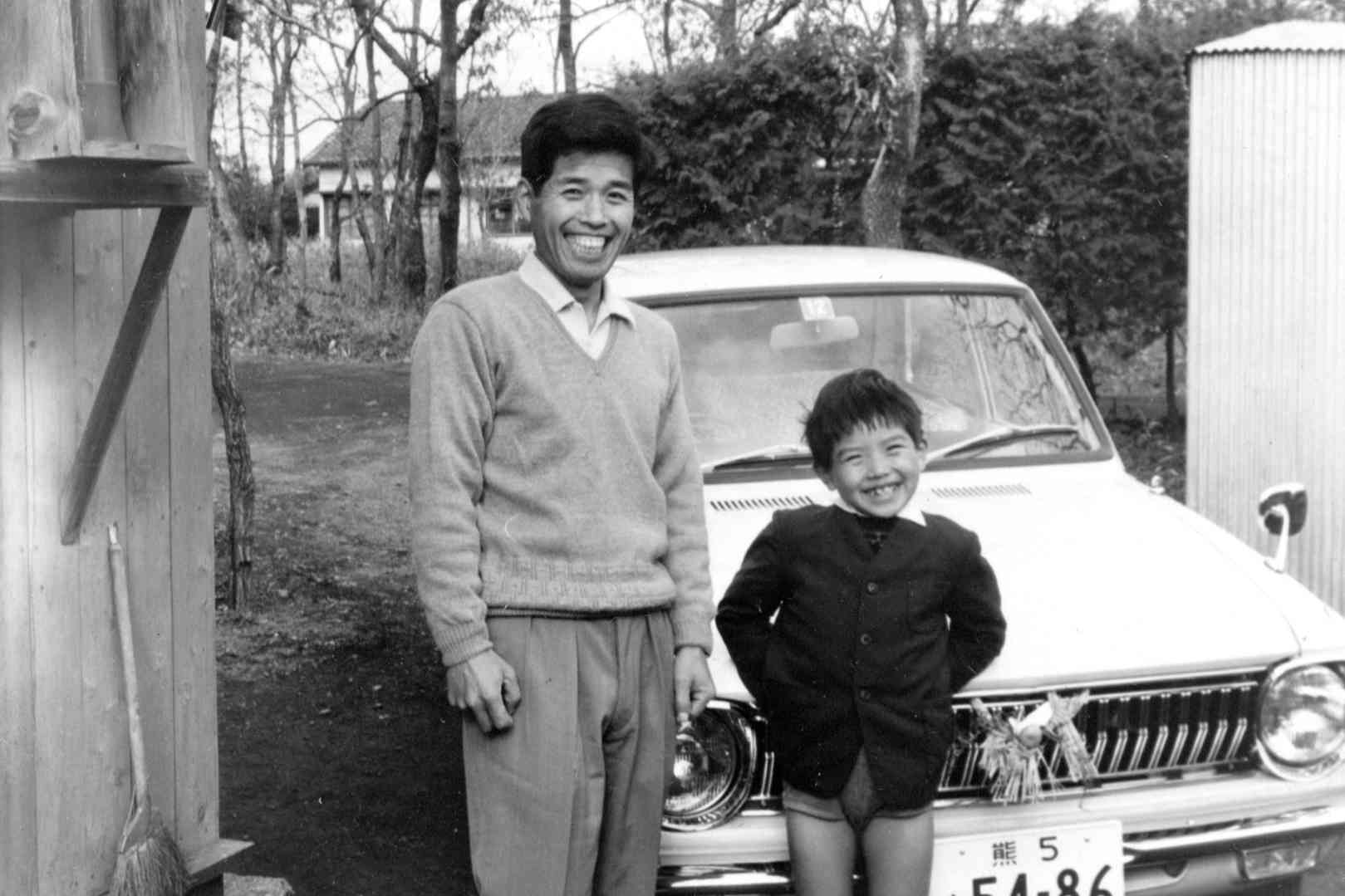 トヨタ・カローラの前に立つ父と私。車には正月飾りがついている