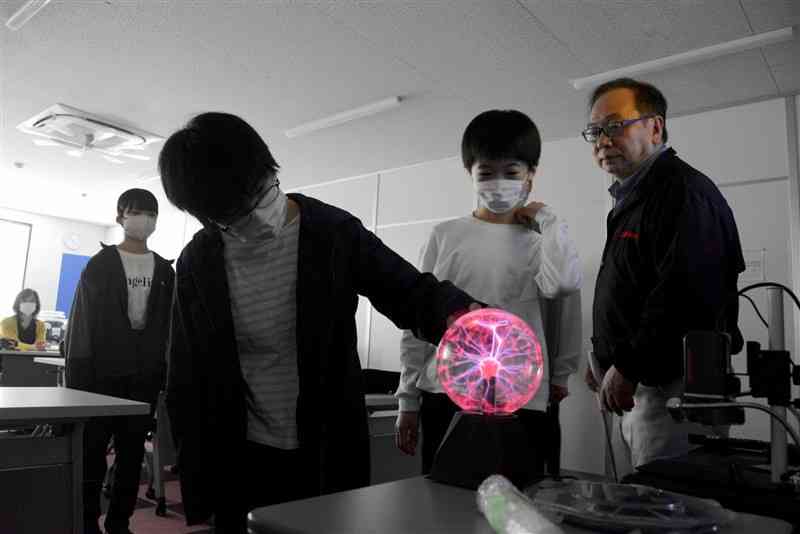 半導体講座でプラズマボールを使って電子の動きを学ぶ中学生＝21日、水俣市