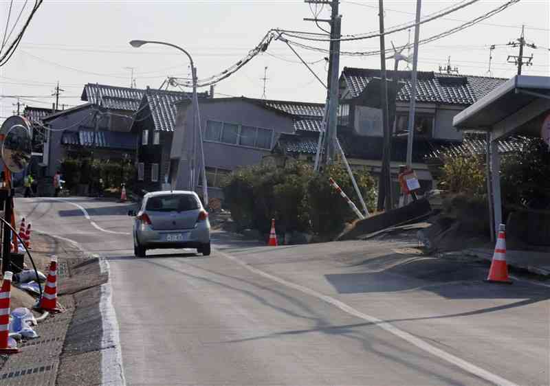 地震による液状化被害で道路が波打ち、建物がかたむいた石川県内＝3月