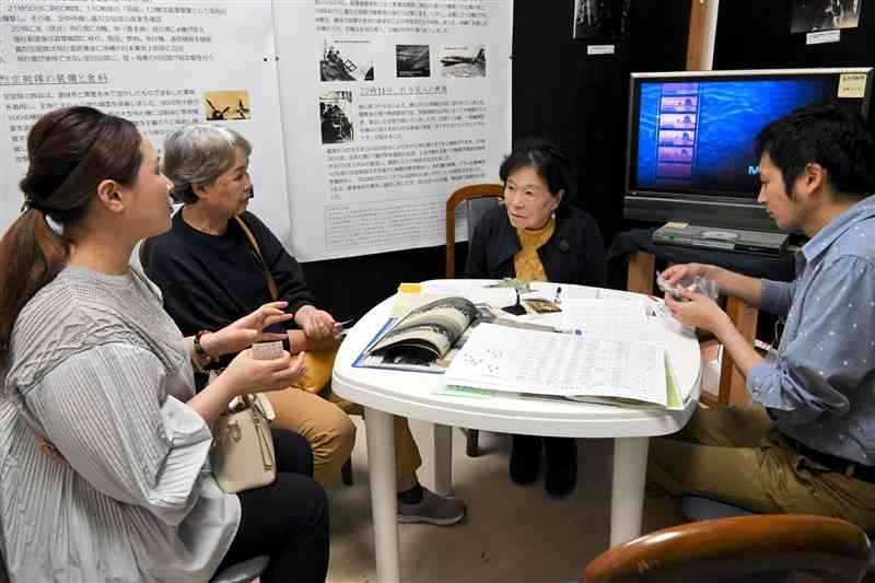 初めて対面した義烈空挺隊の宮本忠一さん、稲津勝さんの遺族。宮本さんの家族（左の2人）と吉野さんの家族（右の2人）が、亡き2人の当時の写真や持参した遺品を手に、思いを巡らせた＝17日、菊池市