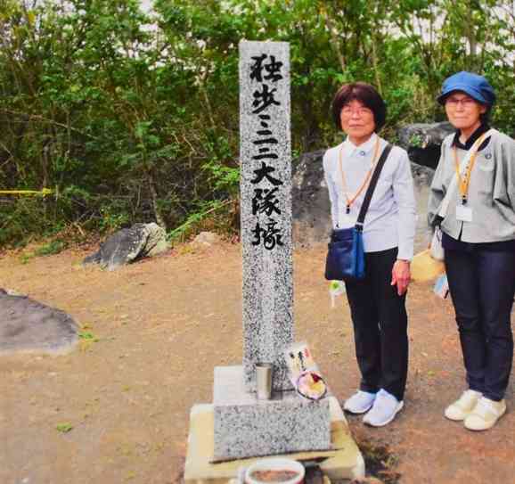 硫黄島で戦死した父親の後藤静雄さんが所属した「独歩三一二大隊」の石柱の横で写真に納まる松岡紀代子さん（左）＝3月30日、東京都小笠原村（松岡さん提供）