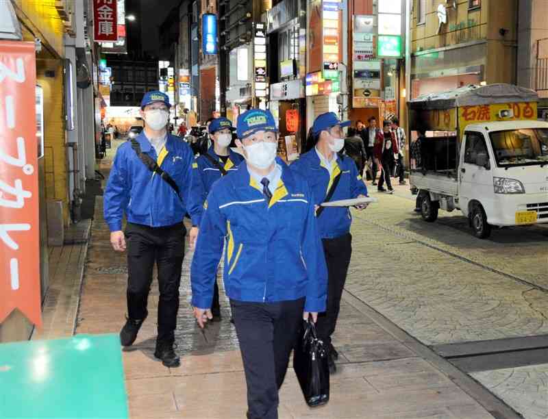 繁華街の飲食店などへ立ち入り調査に向かう警察官ら＝26日夜、熊本市中央区