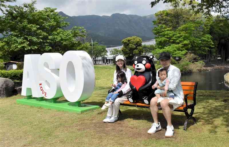 阿蘇中央公園にお目見えした「ASO」の立体看板とくまモン像のあるベンチ＝阿蘇市