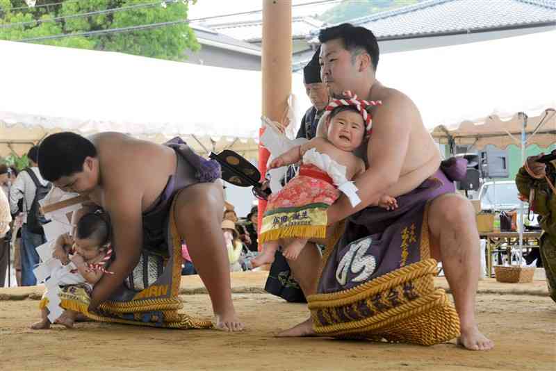 力士に抱きかかえられて土俵入りする赤ちゃん＝28日、芦北町