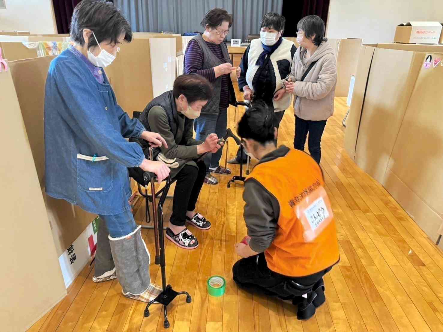 石川県能登町の避難所で、寄付されたつえを高齢者に配る近藤友紀子さん（手前右）＝3月（近藤さん提供）