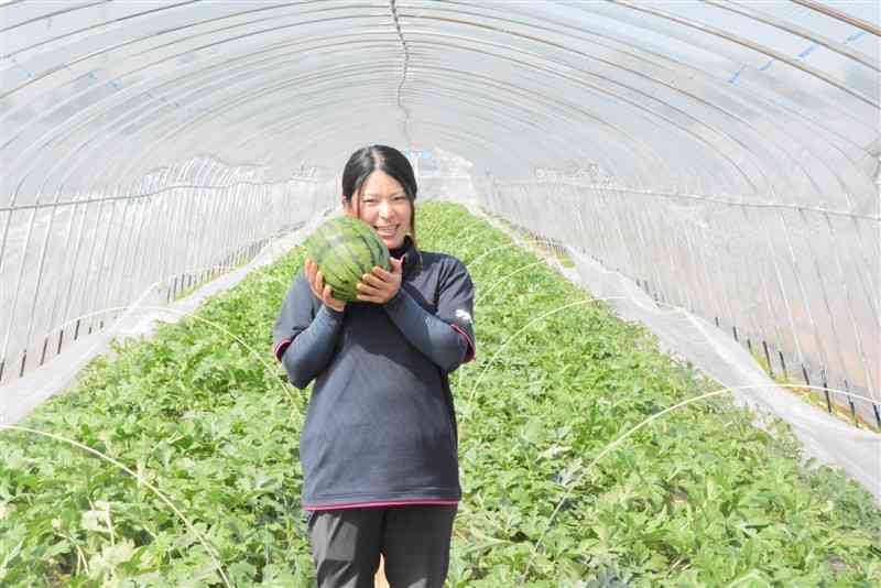 スイカを手にする原口美季さん＝4月10日、熊本市北区