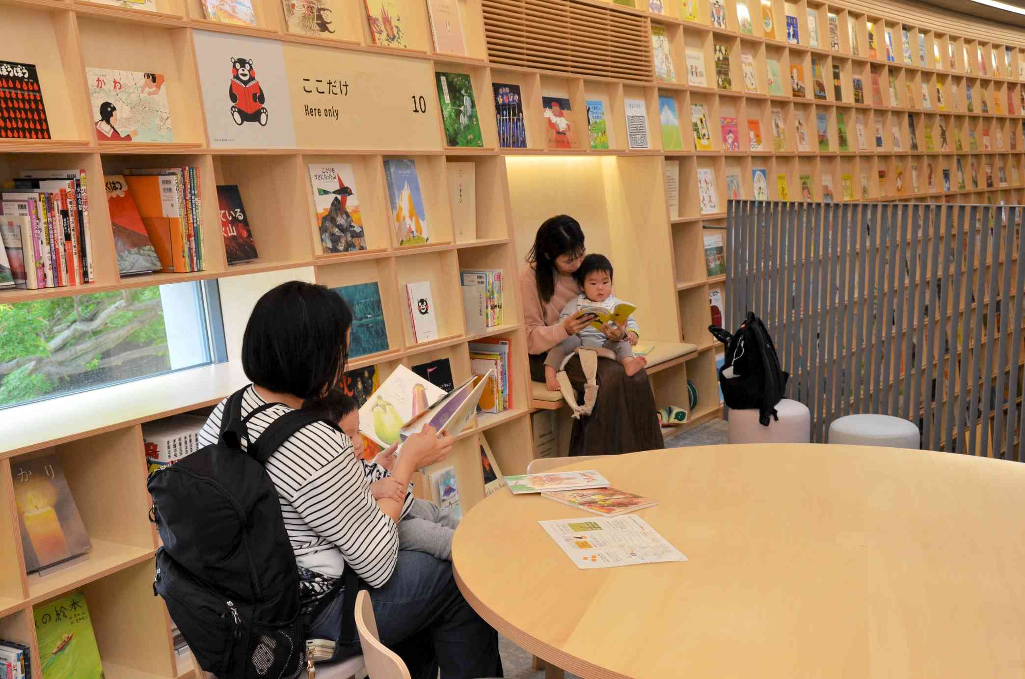 「こども本の森　熊本」で子どもに絵本を読み聞かせする母親ら＝4月24日、熊本市中央区