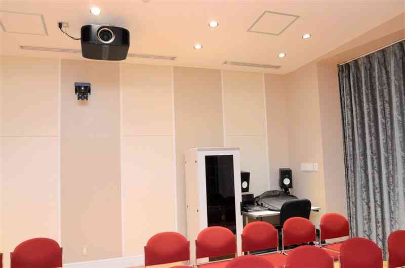 音楽ホールの客席後ろの壁面には遠隔操作できるカメラ、天井には8K対応のプロジェクターが据えられている＝熊本市中央区
