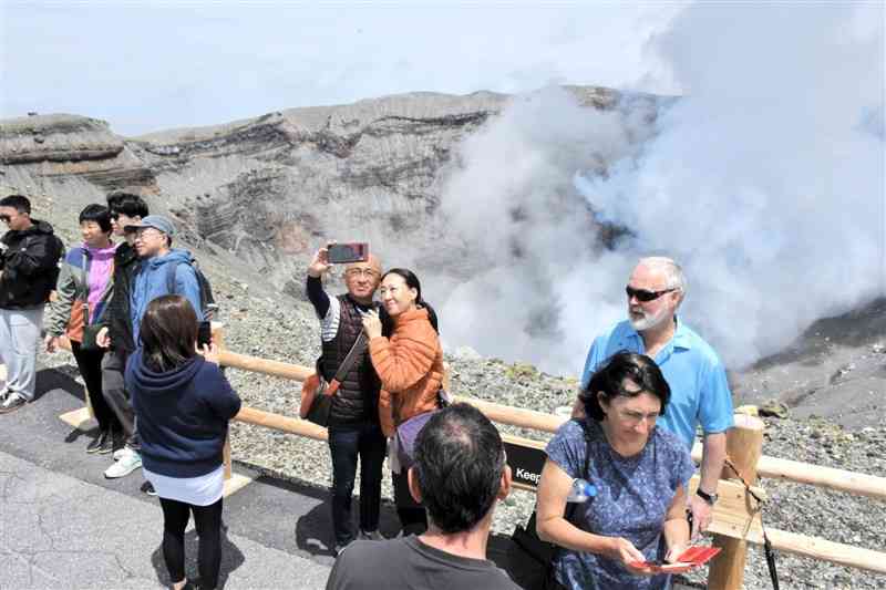 噴煙を上げる阿蘇中岳第1火口を見物する観光客ら＝2日、阿蘇市（宮崎あずさ）