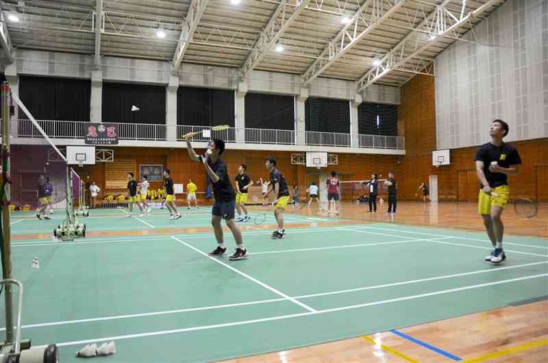 新調された専用コートマットの上で練習する八代東高男子バドミントン部の選手たち＝2日、八代市