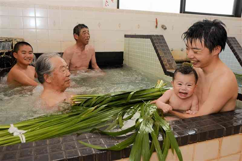 しょうぶ湯を楽しむ親子連れら＝5日、熊本市中央区