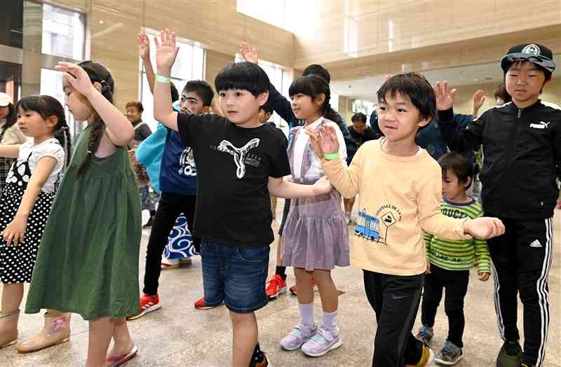 「海風山響フェスタ」で、牛深ハイヤ踊りを体験するくまTOMOサポーターの子どもたち＝6日午前、熊本市中央区の熊日本社