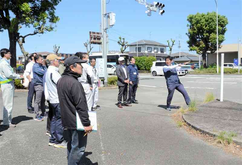 子どもたちが通学路として使う国道57号の交差点を点検する菊陽町の職員ら＝9日、同町