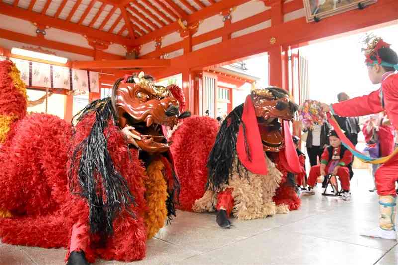 新調された獅子頭と胴衣で舞を披露する中嶋町獅子舞保存会のメンバー＝12日、八代市