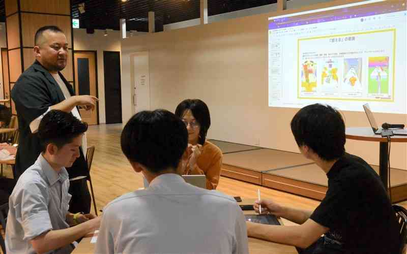 講師の中嶋春貴さん（写真左）の助言を得ながらゲームの構想を考える学生たち＝12日、熊本市西区