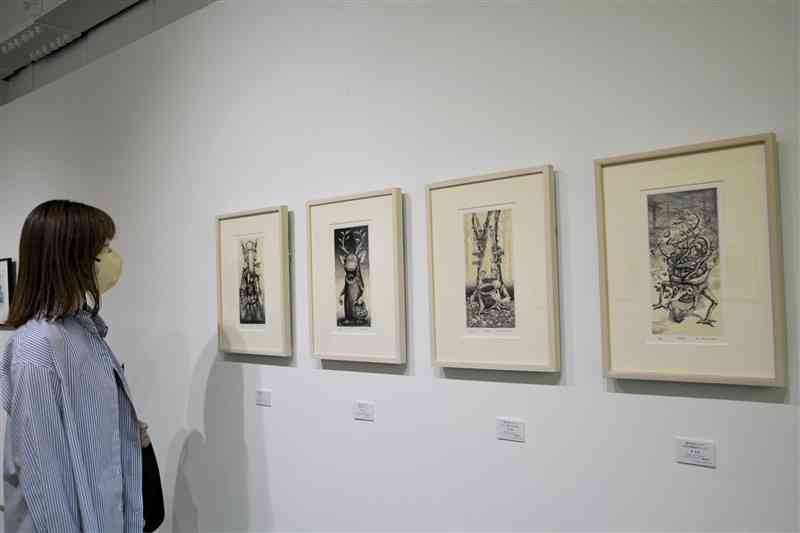 会場で展示中の東弘治さんの銅版画「森の住み人」シリーズ＝19日、熊本市中央区