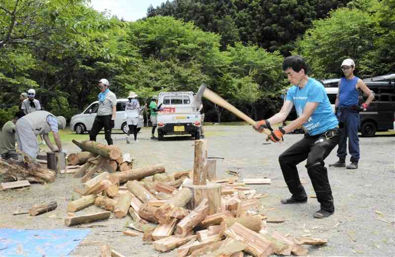 倒木をまきにする「坂本町災害支援チームドラゴントレイル」のメンバー＝19日、八代市
