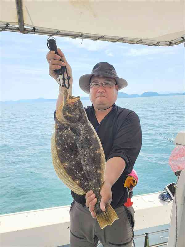 納竿前に60センチ級のヒラメを手にした郷野剛史さん＝長崎県の島原市沖