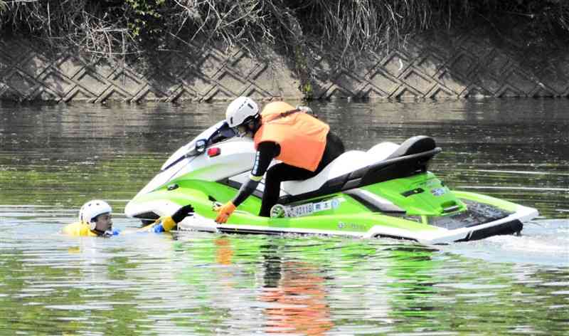 水上バイクで要救助者に近づく機動隊員＝21日、熊本市北区
