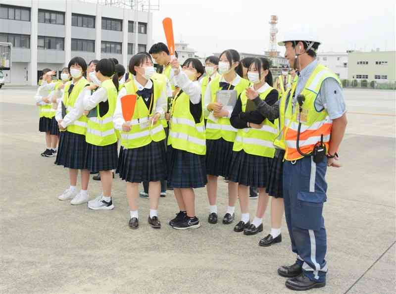 離陸前の航空機を見学する熊本中央高の生徒たち＝22日、益城町