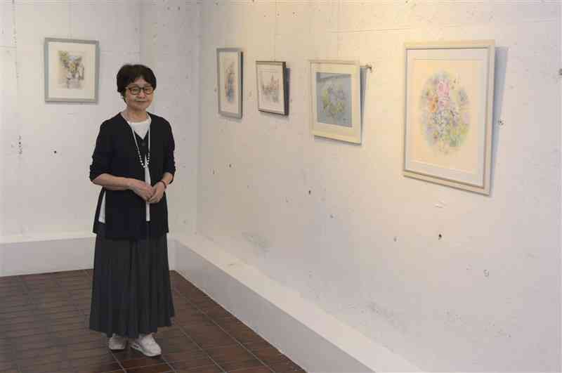 花や風景などを柔らかな色使いで描いた作品を展示している石橋ひさこさん＝23日、熊本市西区
