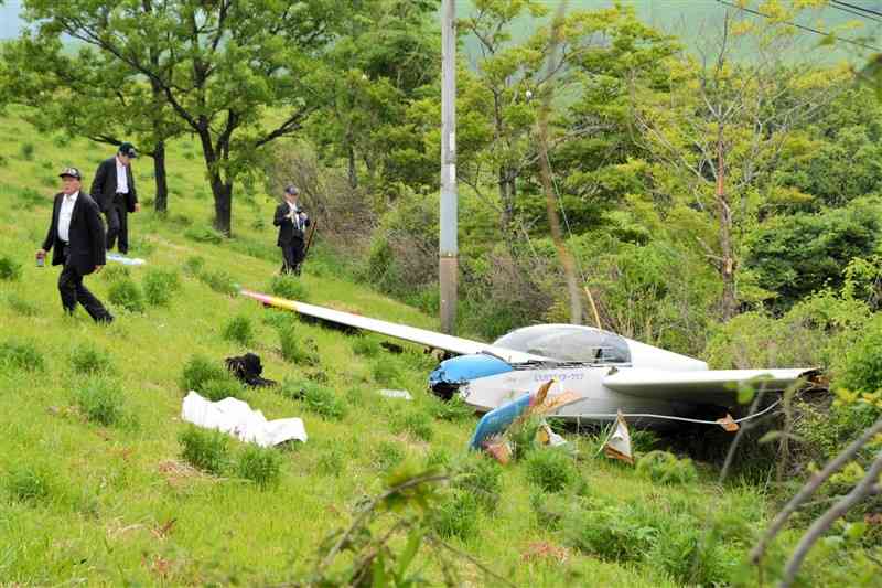 機体の損傷などを調査する航空事故調査官の3人＝26日午後5時ごろ、産山村